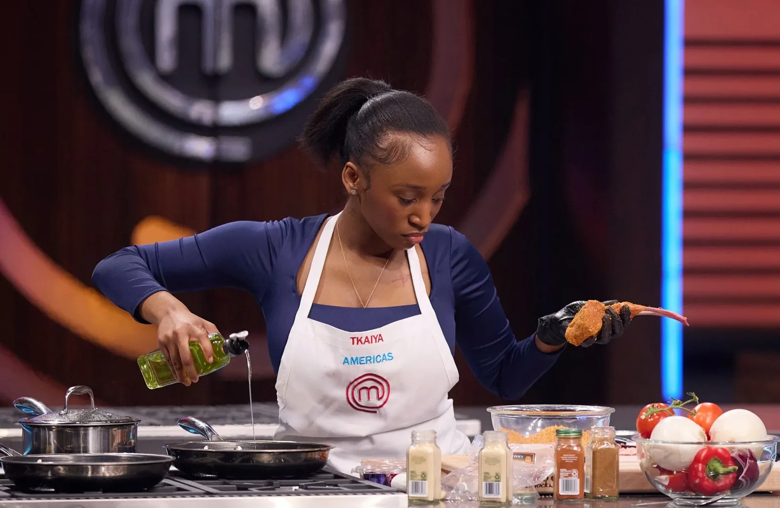 A MasterChef contestant preparing food at her kitchen station.