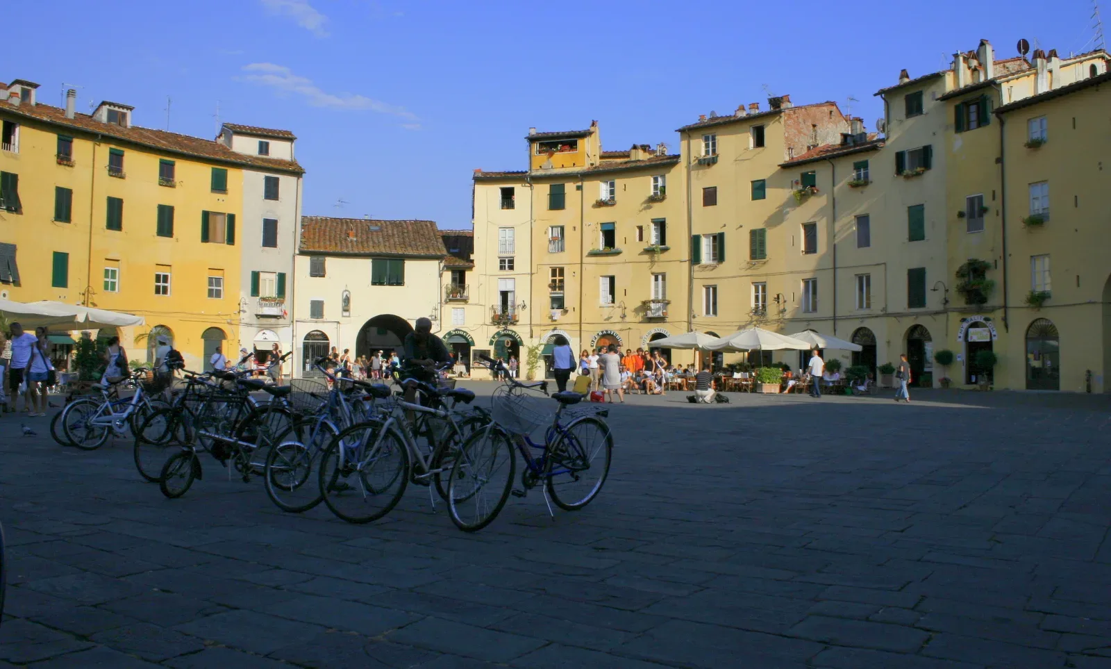 Buildings and cafe terraces surrounding Piazza Anfiteatro in Lucca.