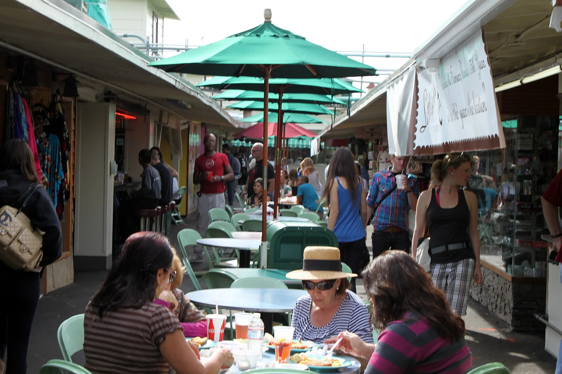 Diners beneath green umbrellas between stalls at the Original Farmers Market.