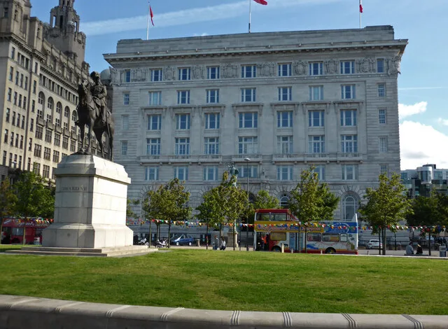 Pale stone facade of the Cunard Building seen across the waterfront lawn.