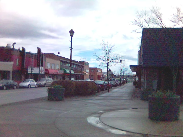 Shops, parked cars and a sidewalk along downtown Cloverdale's main street.