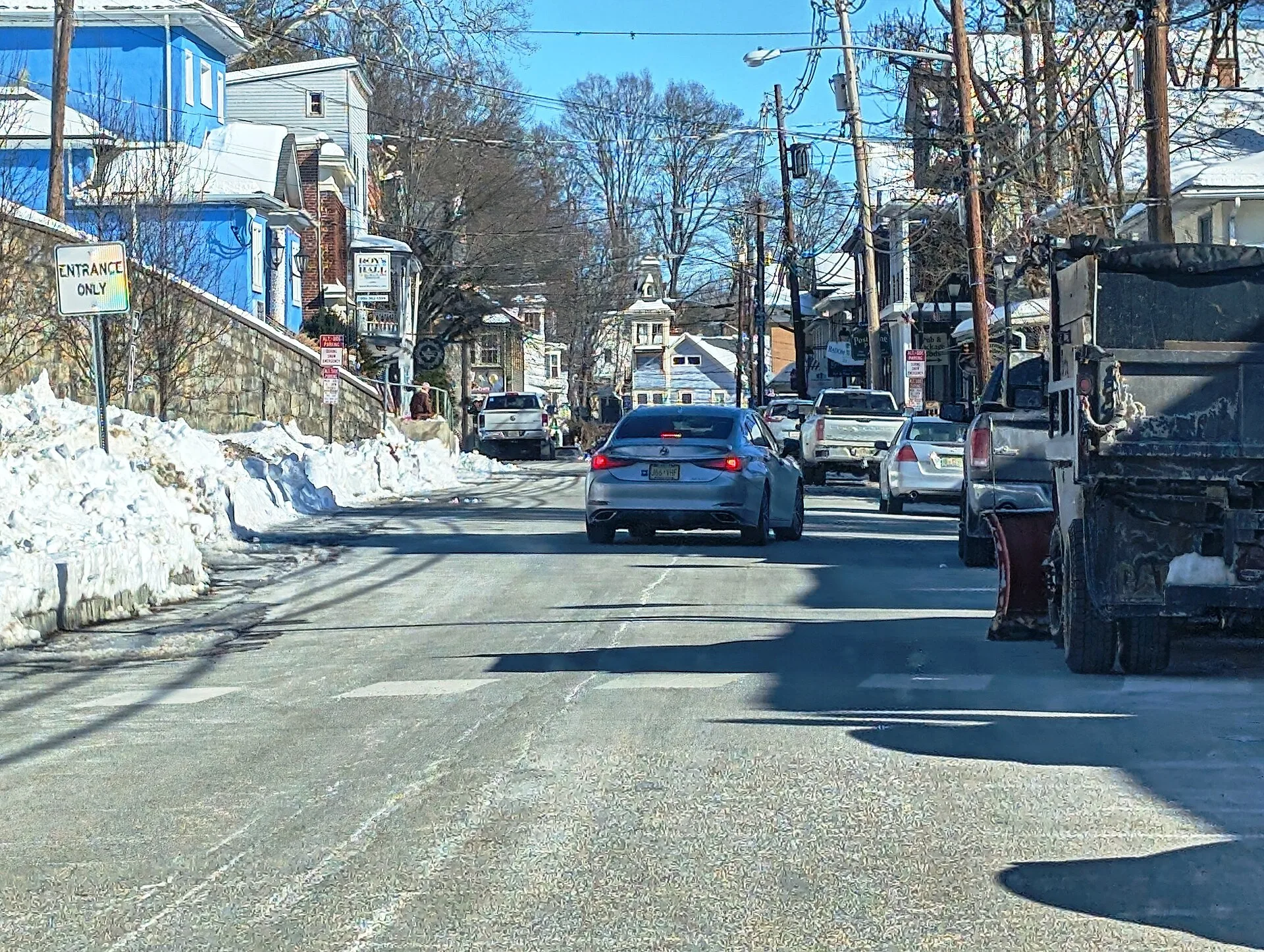 Snow beside the road and historic storefronts in downtown Blairstown.