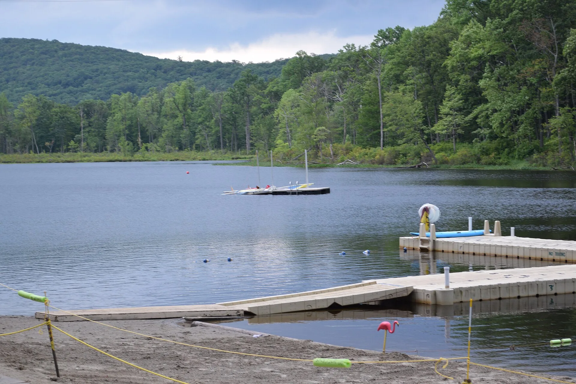 Boats and wooden docks on the wooded lake at Camp No-Be-Bo-Sco.