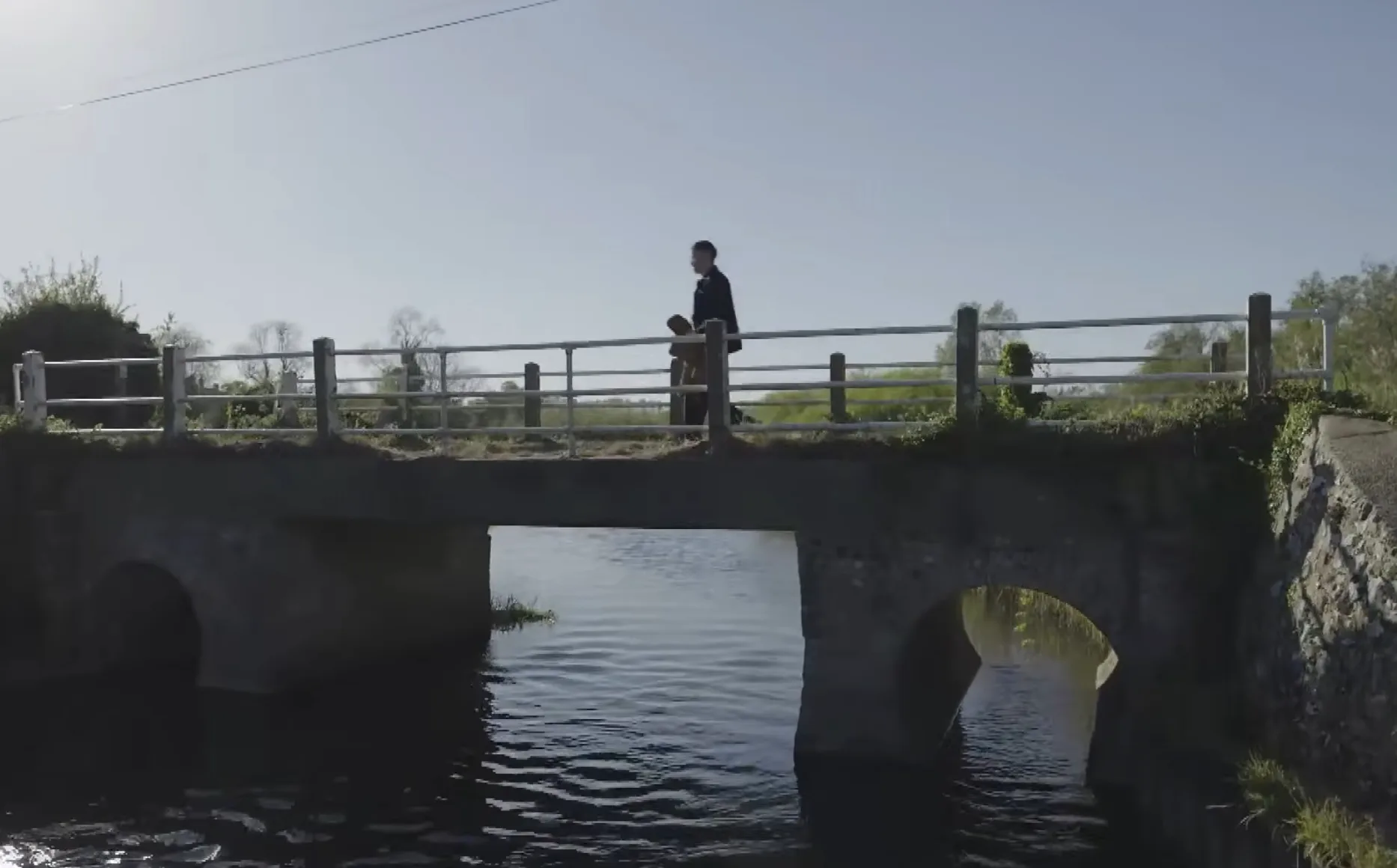 A man and woman crossing a rural bridge in Girl in the Coffin